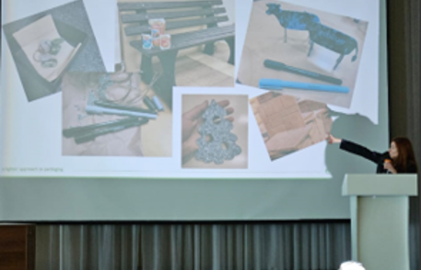 Ecolean's Alina Sadiekova presenting the Green School Project at a school in Astana, with a slide of Ecolean packages behind her.
